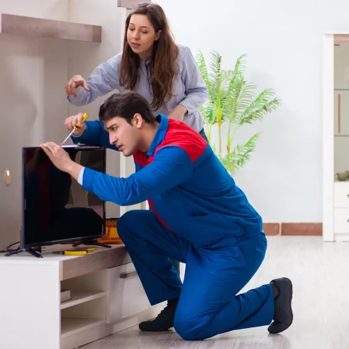 Técnico especializado realizando mantenimiento preventivo de equipos electrónicos en el hogar.